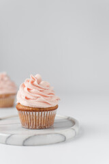 Vanilla cupcake with pink frosting, plain cupcake with pastel pink buttercream