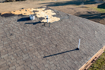 Tornado damage to shingle roof during bad weather.