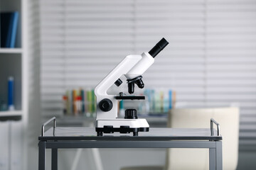 Modern medical microscope on metal table in laboratory