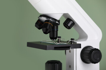 Modern microscope on green background, closeup. Medical equipment