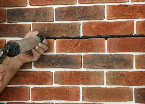 Professional builder using tiling fugue for grouting, closeup