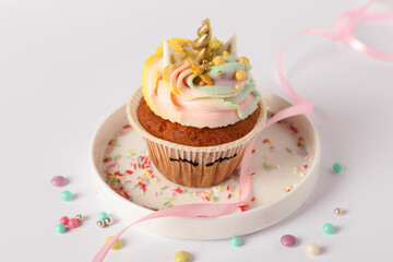 Cute sweet unicorn cupcake on white table