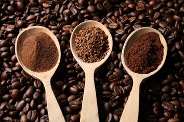 Spoons with different types of coffee on roasted beans, above view