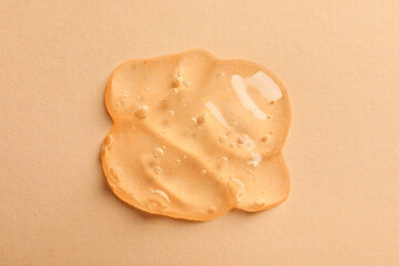 Sample of face gel on pale orange background, top view