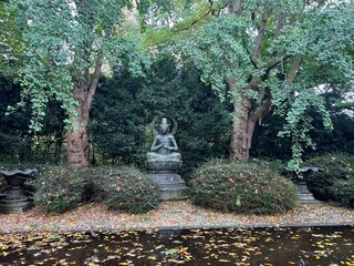 View of Buddha statue near lake in autumn park