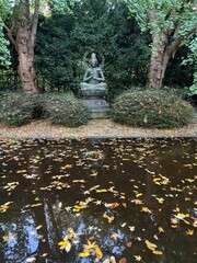 View of Buddha statue near lake in autumn park