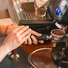 Barista preparing ground coffee in the machine