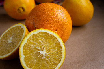 close-up juicy ripe orange cut in half and scattered oranges on a light brown background