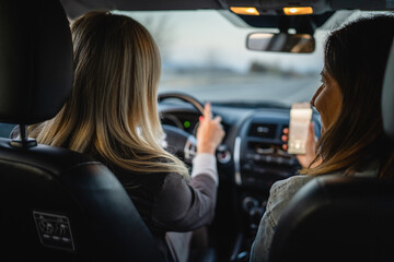 two women drive in a car travel mature caucasian female friends