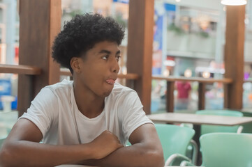 Black teen boy in white shirt with black power hair, various facial expressions and gestures,smiles,copy space left
