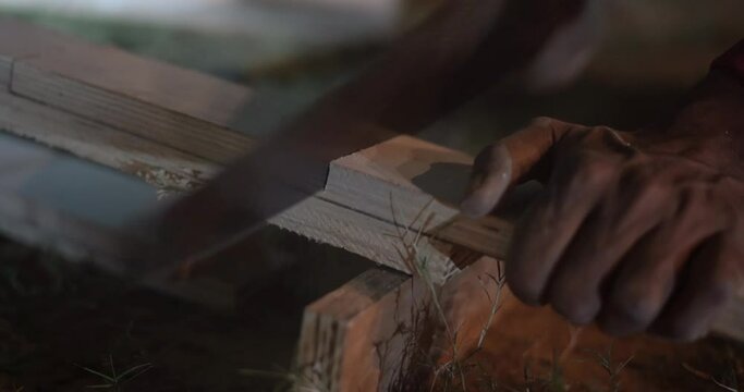 cutting wood block with hand saw old style indian hand saw for wood cutting at night indina  close up