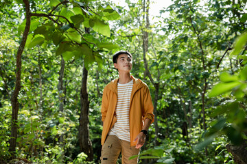 Asian teenager hike through forest to peak of mountain, Admiring nature, relaxing.