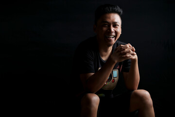young asian man portrait smiling isolated black background