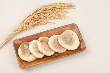 one of the Chinese rice cakes Knead flour or glutinous rice flour, add the filling with sugar, and bake it wide on a pan or in a bun season
 중국식 떡의 하나. 밀가루나 찹쌀가루를 반죽하여 설탕으로 소를 넣고 번철이나 프라이팬 따위에 둥글넓적하게 