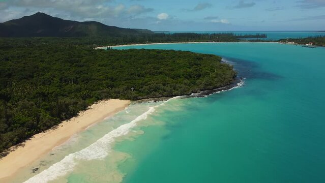 The Isle of Pines' beaches at Bay of Rouleaux in the foreground with the beach at Kuto Bay in the background - pull back aerial reveal