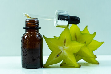 aromatic oil. Carambola essential oil (star fruit) on a white background. Selective focus. 