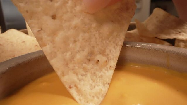 Tortilla chip dipped in queso cheese macro