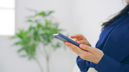 室内でスマホを使う女性