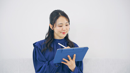 室内でタブレットPCを使う女性 © metamorworks