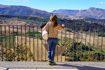 Woman contemplating the mountainous landscape of a viewpoint in the mountain of Grazalema, Cadiz. - obrazy, fototapety, plakaty