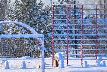 Snow-covered empty school stadium on a winter day