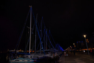 Fototapeta na wymiar Beautiful seaside town at night, Christmas and New Year festive season, Volos, Greece ,Sail Boat Holiday Lights, decorated city for the Christmas holidays,