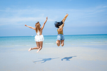 Two attractive girls jumping on the beach,Having Fun,Summer Lifestyle.