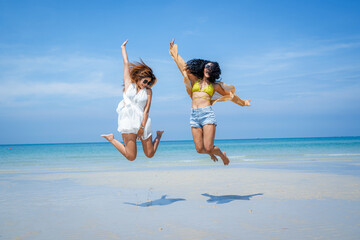 Two attractive girls jumping on the beach,Having Fun,Summer Lifestyle.