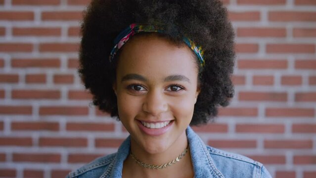 Black woman, brick wall and smile on face, thinking or curly afro hair in workspace for online marketing job. Seo, content creator and happy creative with vision, career goal or innovation in Atlanta