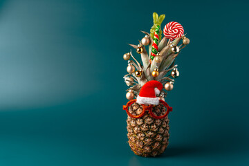 Creative pineapple with Christmas decorations on studio background