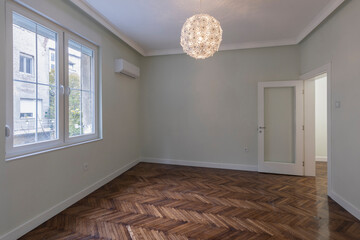 Interior of an empty apartment with brown wooden parquet