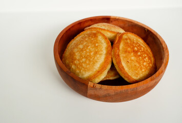 Kue Samir or Kamir or Khamir, a traditional pancake from Pemalang, Indonesia, on a wooden bowl isolated with white background
