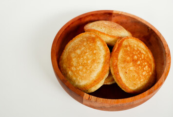 Kue Samir or Kamir or Khamir, a traditional pancake from Pemalang, Indonesia, on a wooden bowl isolated with white background