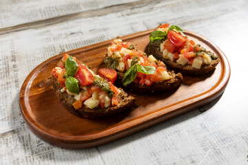 Bruschetta with cherry tomato and pesto served on a wooden board