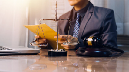 Business and lawyers discussing contract papers with brass scale on desk in office. Law, legal services, advice, justice and law concept picture with film grain effect