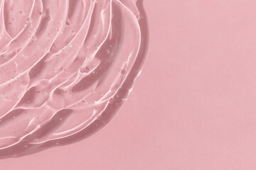 Transparent serum gel with hyaluronic acid for the face on a pink background. The texture of a...