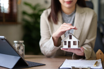 female real estate agent offers home equity loans to clients with loan calculations and home sales...