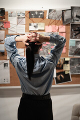 Lady private agent or detective looking at crime investigation board, back view