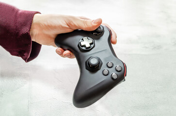 man holds wireless game controller in hand, gamepad for videogames. Hand demonstrates gamepad