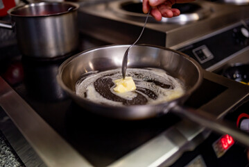 chef frying butter in pan at kitchen