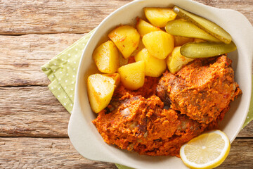 Macanese African Chicken Galinha a Africana close up on the pot on the table. Horizontal top view from above