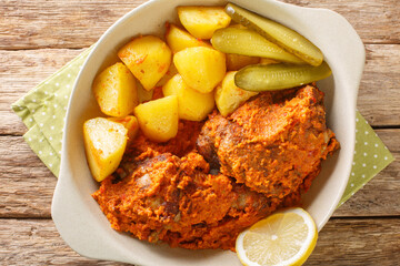 African and Portuguese cuisine galinha a Africana or frango assado is a dish traditionally associated with Macau close up on the pot on the table. Horizontal top view from above