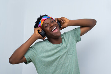 young handsome man wearing shirt listening to music on an headphone