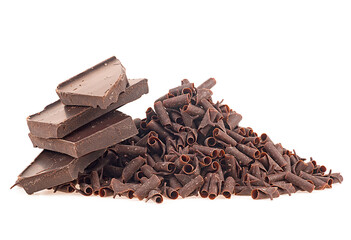 Pile of chocolate curls and broken chocolate bar isolated on a white background. Chocolate flakes.