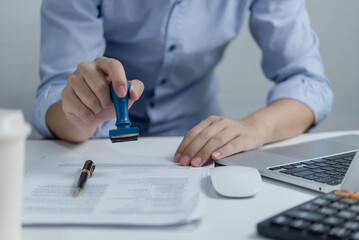 Man stamping approval of work finance banking or investment marketing documents on desk.