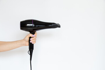 Professional hairdressing hair dryer in the hands of a girl on a white background