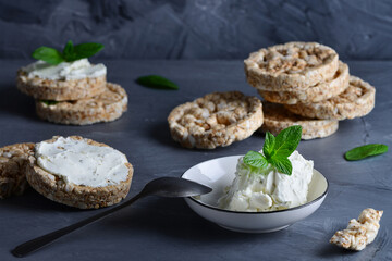 Curd cheese and whole grain crispbreads on a gray table
