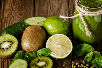 Blended green smoothie with ingredients on the wooden table. Green cocktail. Healthy food 