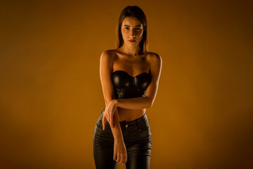 Girl standing and posing in black leather clothes