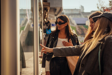 Fototapeta premium A blonde girl pointing to a beautiful handbag